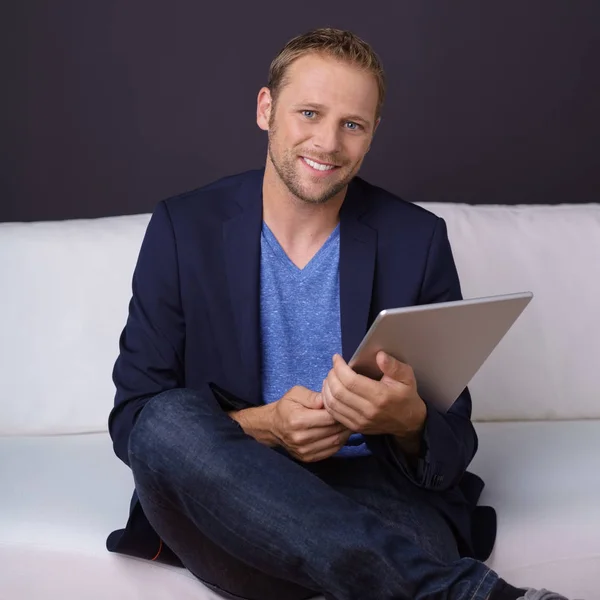 Jeune homme intelligent relaxant à la maison avec une tablette — Photo