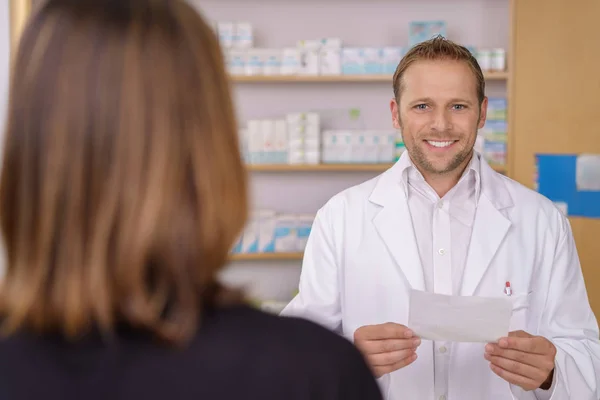 Pharmacien amical et souriant aidant un patient — Photo