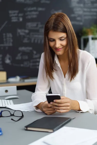 Junge Geschäftsfrau checkt ihr Handy — Stockfoto