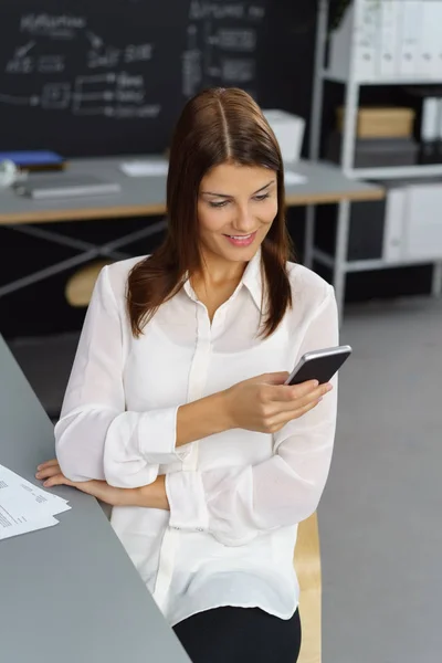 Attraktive junge Frau checkt ihr Smartphone — Stockfoto