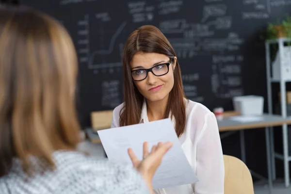 Unimpressed woman listening to a colleague — Stock Photo, Image
