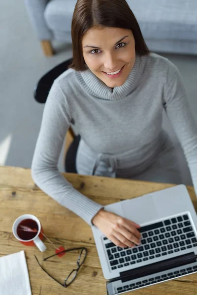 Usmívající se žena pracující v přenosném počítači — Stock fotografie