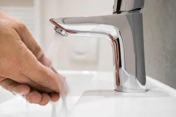 Persona che si risciacqua le mani sotto l'acqua corrente — Foto Stock