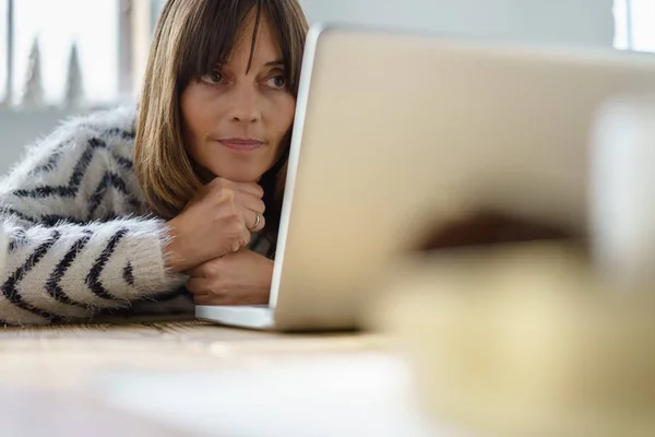 Ontspannen zakenvrouw bestuderen van de gegevens op haar laptop — Stockfoto