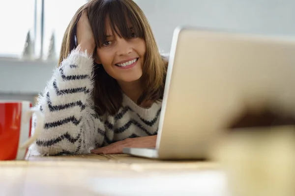 Усміхнена дружня жінка дивиться навколо ноутбука — стокове фото