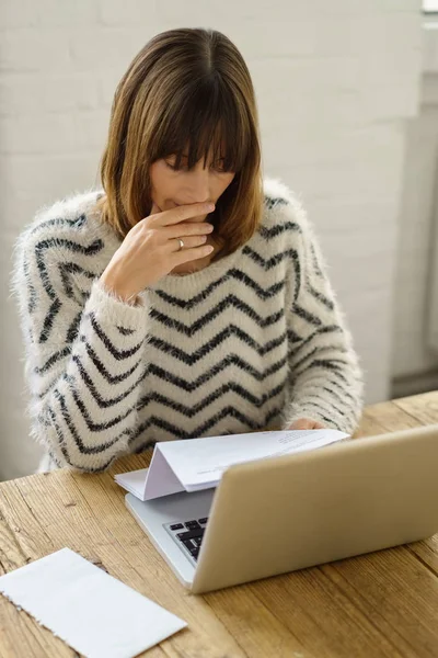 Mulher lendo uma carta sentada em seu laptop — Fotografia de Stock