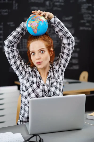 Возбужденная женщина держит глобус на голове — стоковое фото