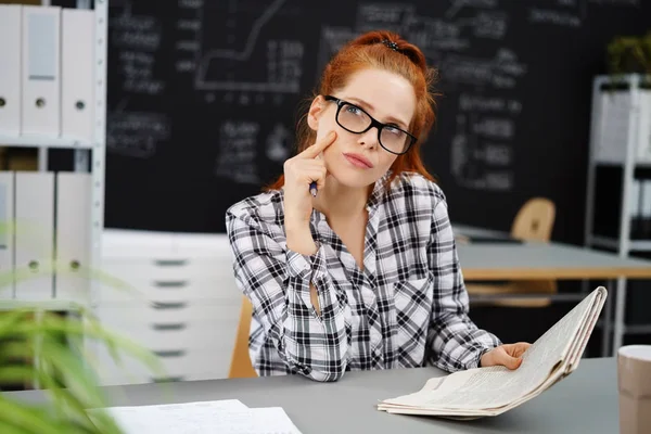 Ernstige vrouw denken over haar aantekeningen in de klas — Stockfoto