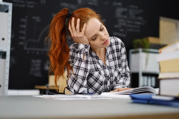 Serious student reviewing work at desk in class — Stock Photo, Image