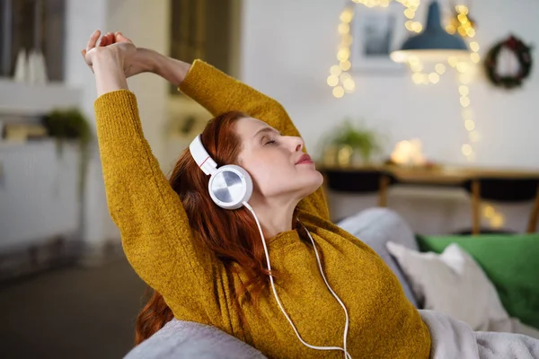 Gözlü kadın kapatmak earphones ile germe — Stok fotoğraf