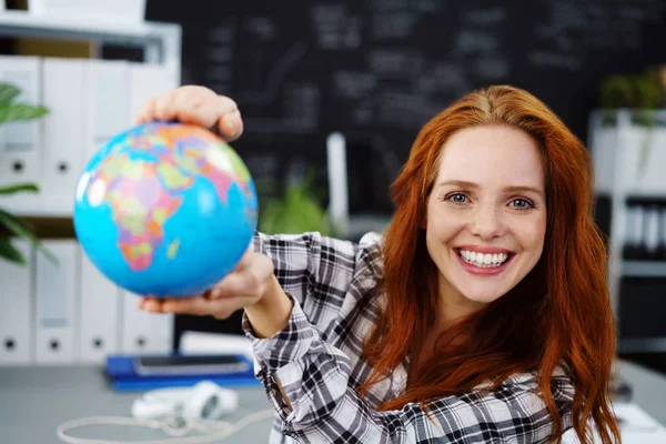 Mulher alegre segurando pequeno globo em sala de aula — Fotografia de Stock