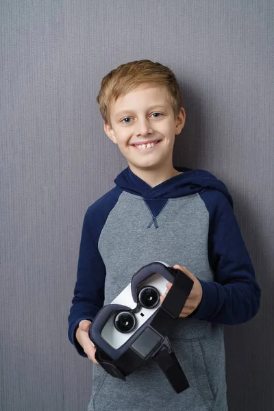 Joven niño sosteniendo auriculares VR — Foto de Stock