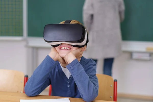 Boy in classroom wearing VR headset