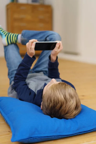 Kleiner Junge entspannt sich mit seinem Handy — Stockfoto