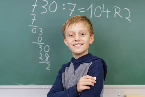 Proud young boy doing mathematics in school