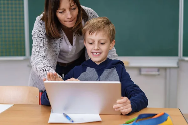 Teacher helping a little boy in class — Stock Photo, Image