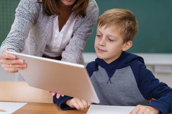 Intéressé jeune écolier regardant une tablette — Photo