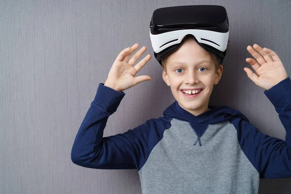 Захоплений молодий хлопчик з піднятим гарнітуром VR — стокове фото