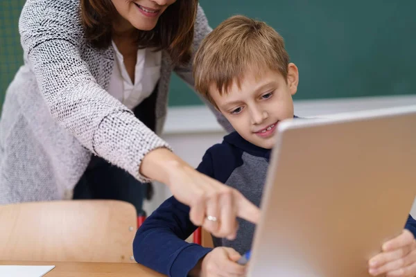 Profesor señalando algo a un joven estudiante — Foto de Stock