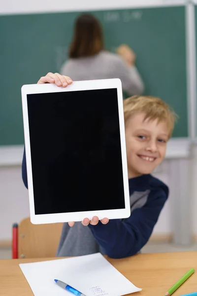 Ler skolpojke som håller upp en tom tablett — Stockfoto