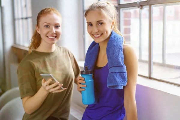 Девушки со смартфоном после тренировки — стоковое фото