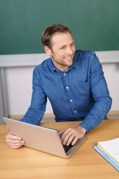 Teacher in classroom working with laptop — Stock Photo, Image