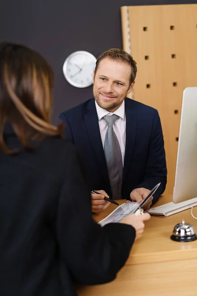 Smiling hotel manager presenting a bill