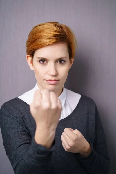 Mujer joven mostrando puños — Foto de Stock