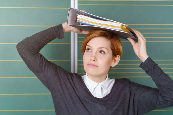 Woman covering head with folder — Stock Photo, Image