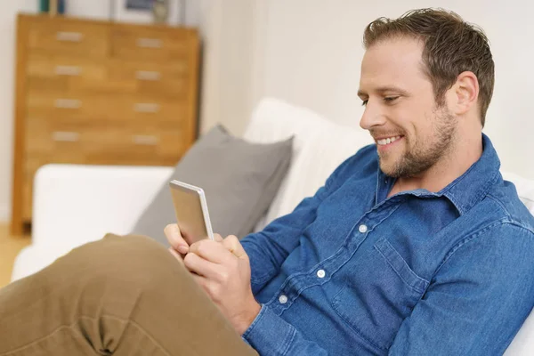 Mann mit Smartphone zu Hause — Stockfoto