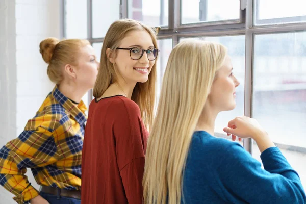 Kvinnliga studenter tittar ut ur fönster — Stockfoto
