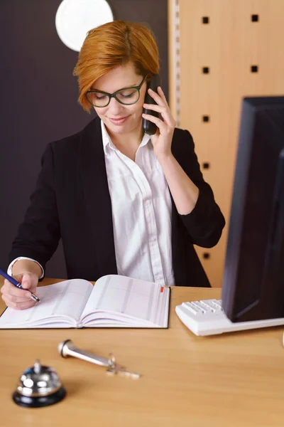 Jonge roodharige hotelreceptionist — Stockfoto