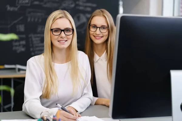 Mujeres en el escritorio frente a la computadora — Foto de Stock