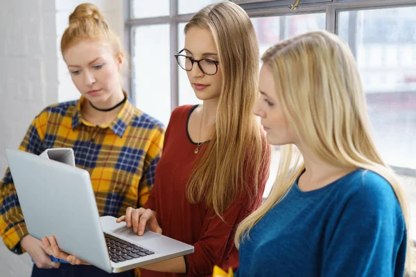 Estudantes do sexo feminino partilha laptop — Fotografia de Stock