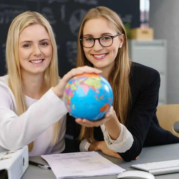 Mulheres com globo no local de trabalho — Fotografia de Stock