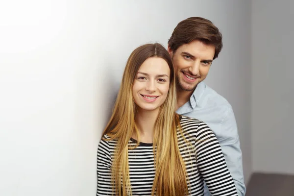 Young couple leaning on white wall — Stock Photo, Image