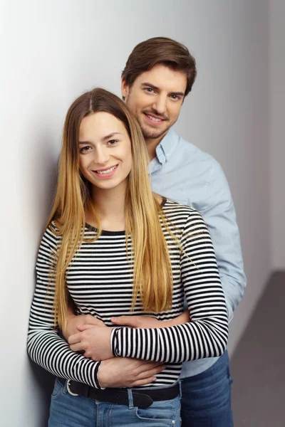 Jovem casal inclinado na parede branca — Fotografia de Stock