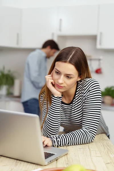 Thoughtful young woman using laptop — Stock Photo, Image