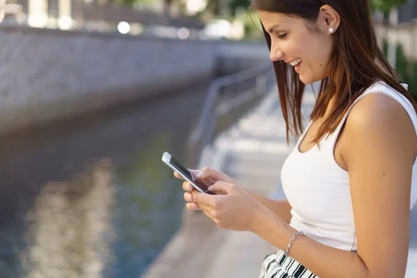 Entspannte junge Frau liest SMS — Stockfoto
