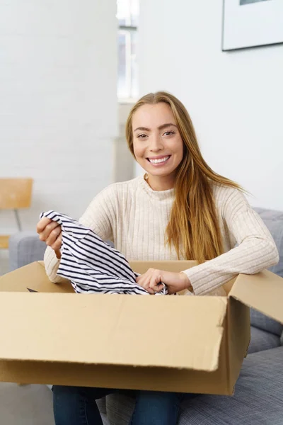 Woman unpacking cardboard package — Stock Photo, Image