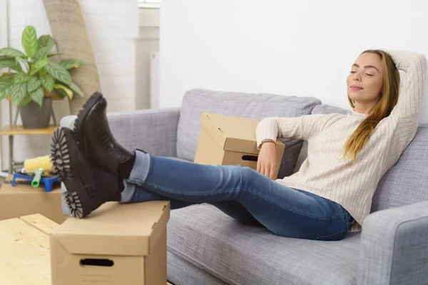 Young woman sitting on sofa — Stock Photo, Image