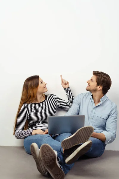 Glückliches entspanntes Paar zeigt auf Kopierraum — Stockfoto