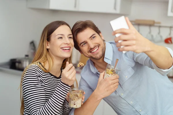 Riendo joven pareja tomando una selfie — Foto de Stock