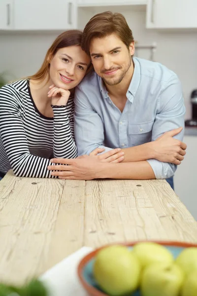 Casal jovem afetuoso sentado a uma mesa — Fotografia de Stock