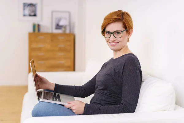 Mulher no sofá com laptop — Fotografia de Stock