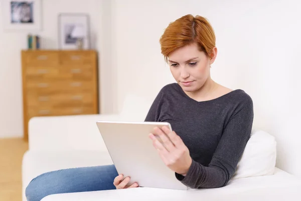 Mujer joven mirando la pantalla de la tableta — Foto de Stock