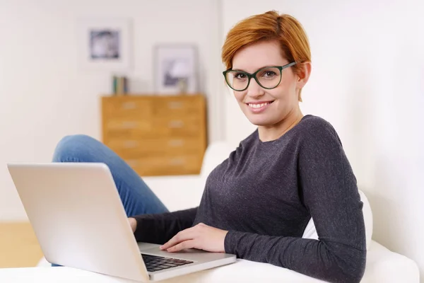 Junge kastanienbraune Frau entspannt mit Laptop — Stockfoto