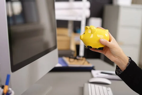 Businesswoman holding up a yellow piggy bank — Stock Photo, Image