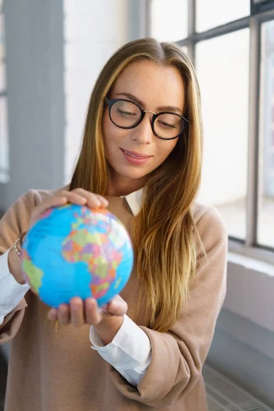 Jovem empresária segurando um globo mundial — Fotografia de Stock