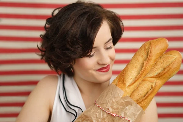 Bella giovane donna che tiene baguette appena sfornate — Foto Stock